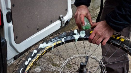il tecnico sta cospargendo d’acqua saponata uno pneumatico che non ne vuole sapere di tallonare! (fonte:basquemtb.com)