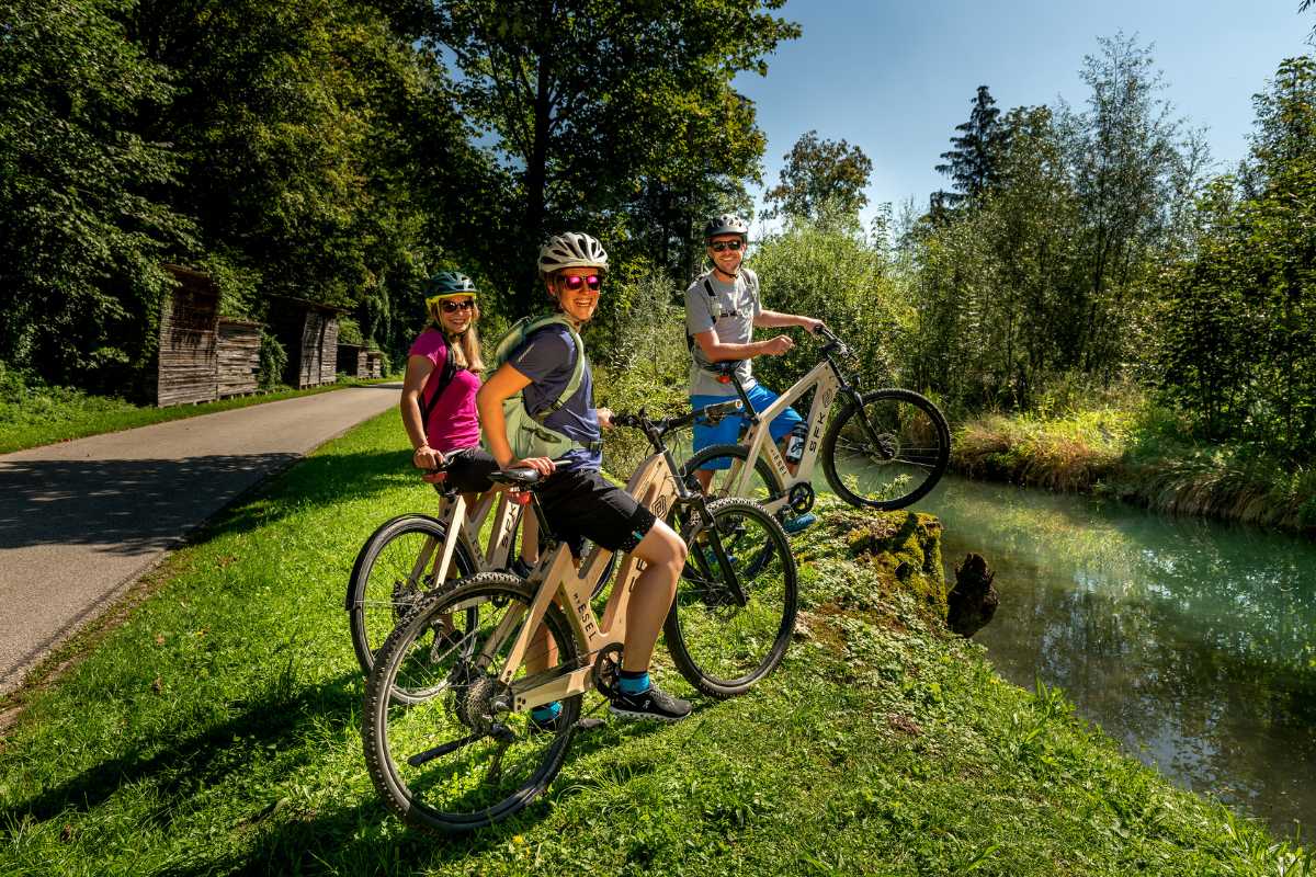 Famiglia in ebike lungo un percorso ciclabile per vacanze in bici in Italia