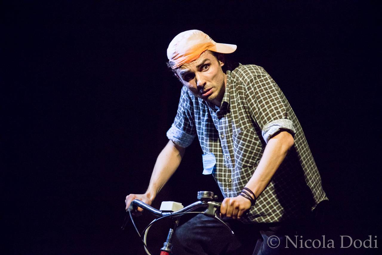 Daniele Ronco attore in bici durante uno spettacolo