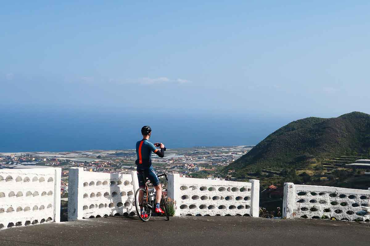 Ciclista in pausa che guarda l'oceano a Tenerife