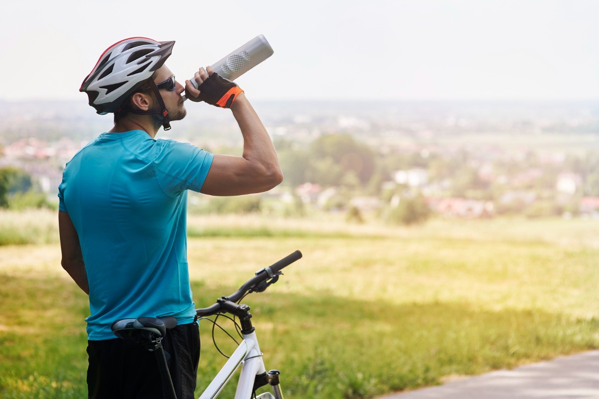 Caldo bici ciclista beve acqua per dissetarsi