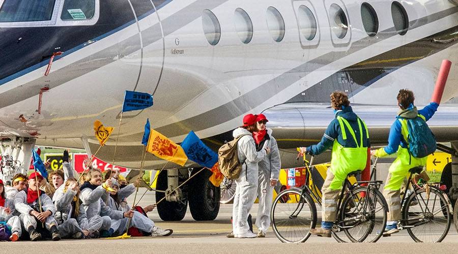 Attivisti in bici per il clima bloccano i jet privati all'aeroporto Schiphol di Amsterdam